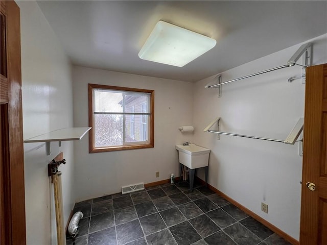 washroom with visible vents, baseboards, and a sink