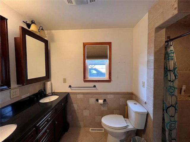 full bathroom featuring visible vents, tiled shower, wainscoting, tile walls, and toilet