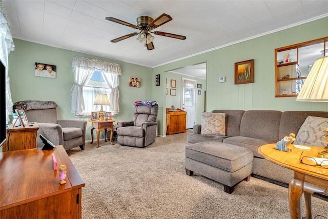 living area with carpet flooring, ceiling fan, and ornamental molding