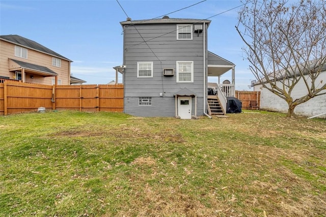 back of property with stairway, a lawn, and a fenced backyard