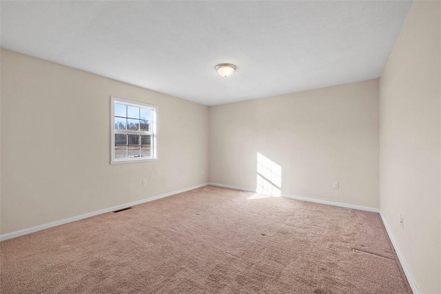 carpeted spare room with visible vents and baseboards