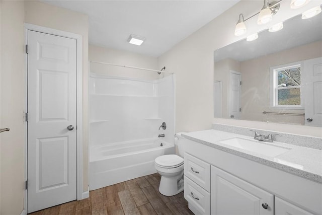 full bathroom featuring vanity, toilet, wood finished floors, and bathtub / shower combination