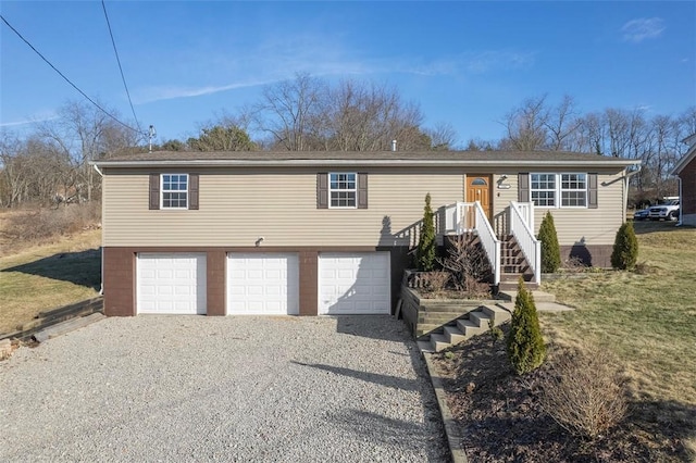 view of front of house with a garage and gravel driveway