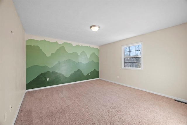 empty room with visible vents, baseboards, and carpet flooring