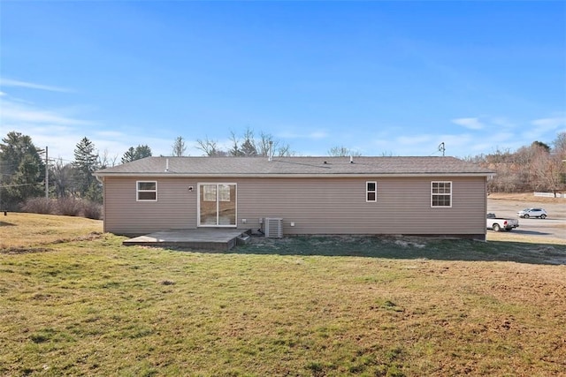 rear view of house with a lawn and central AC