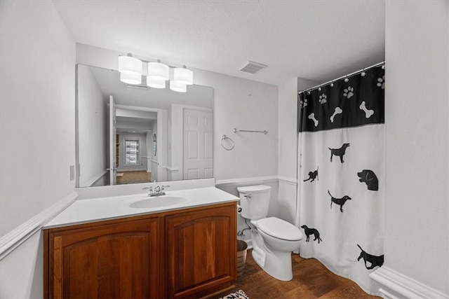 full bath featuring vanity, a shower with shower curtain, wood finished floors, visible vents, and toilet