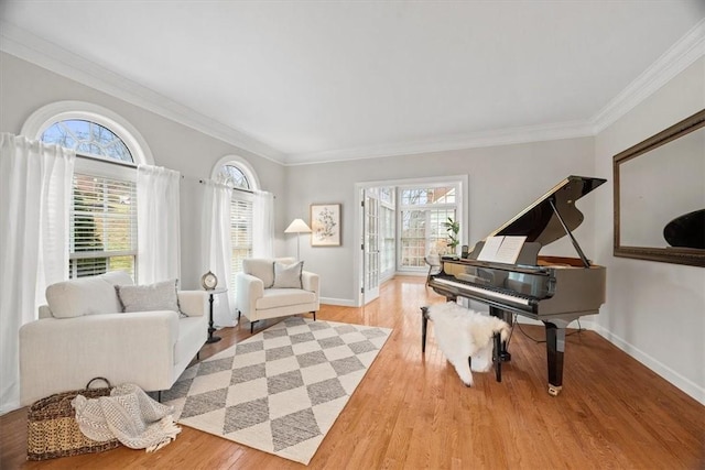 living area with a healthy amount of sunlight, baseboards, and wood finished floors