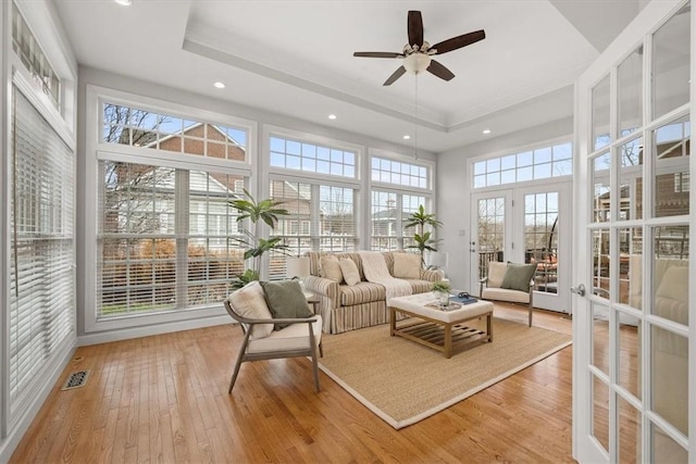 sunroom featuring a tray ceiling, visible vents, and ceiling fan