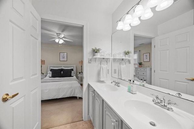 bathroom with a sink, double vanity, ceiling fan, and ensuite bathroom