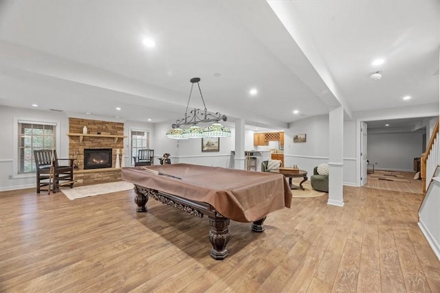 recreation room featuring pool table, baseboards, light wood-type flooring, a stone fireplace, and recessed lighting