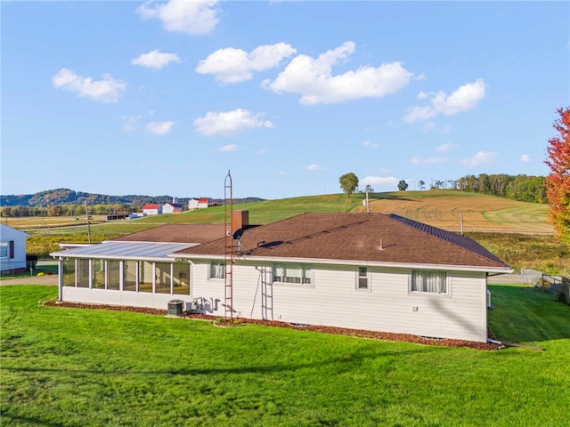 back of property featuring a yard, central AC unit, and a sunroom