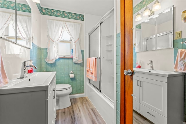 full bathroom featuring vanity, tile walls, and wood finished floors