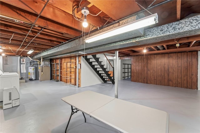 unfinished basement featuring water heater, heating unit, wood walls, and stairs