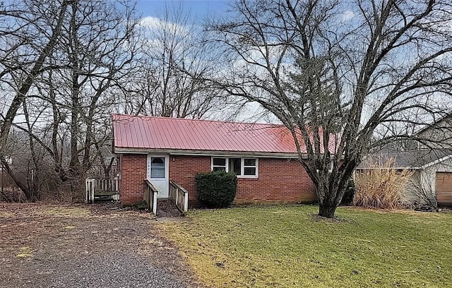 view of property exterior with metal roof, a yard, and brick siding