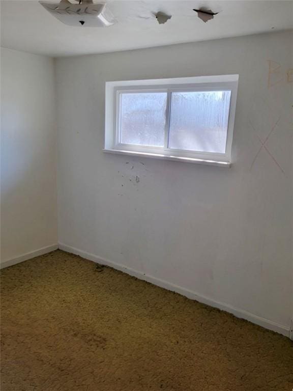 unfurnished room featuring carpet and baseboards