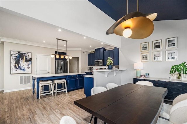 dining area featuring visible vents, ornamental molding, recessed lighting, light wood finished floors, and baseboards