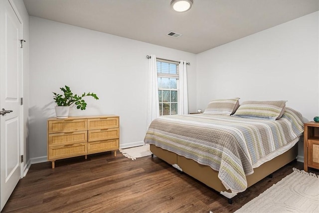 bedroom with visible vents, baseboards, and dark wood-style floors