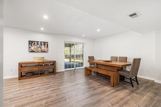 dining space with visible vents, baseboards, and wood finished floors