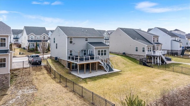 back of house with a residential view, a wooden deck, stairs, a yard, and a fenced backyard