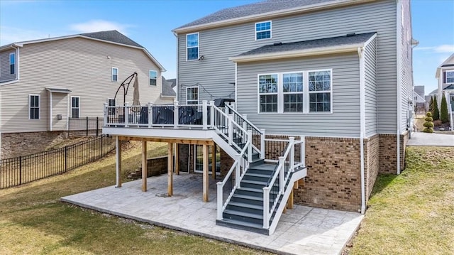 rear view of house featuring a deck, a patio, fence, a yard, and stairs