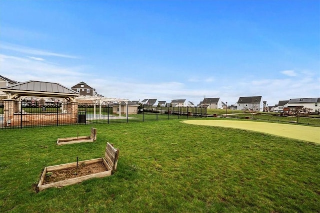 view of home's community with a lawn, fence, and a vegetable garden