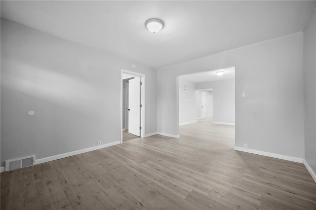 unfurnished room with visible vents, baseboards, and wood finished floors