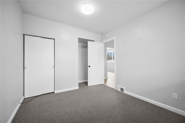 unfurnished bedroom featuring baseboards, visible vents, and carpet floors