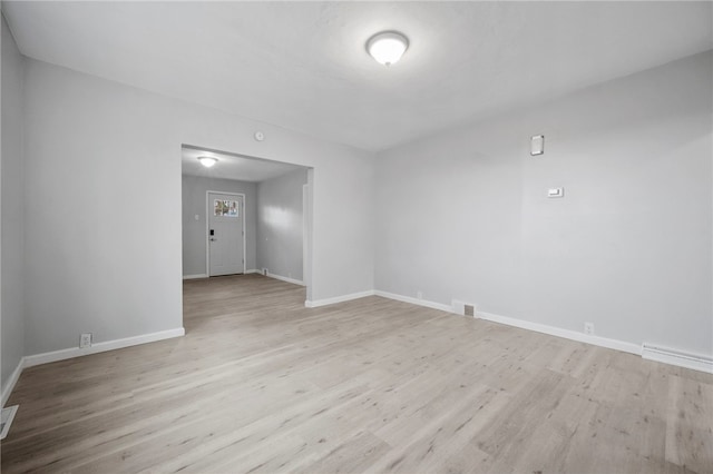 unfurnished room featuring visible vents, baseboards, and wood finished floors