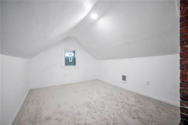 additional living space featuring vaulted ceiling, carpet, visible vents, and baseboards