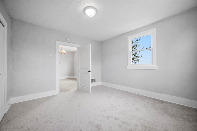 unfurnished bedroom featuring a notable chandelier, carpet flooring, and baseboards