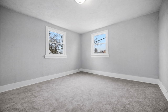 empty room with baseboards and carpet