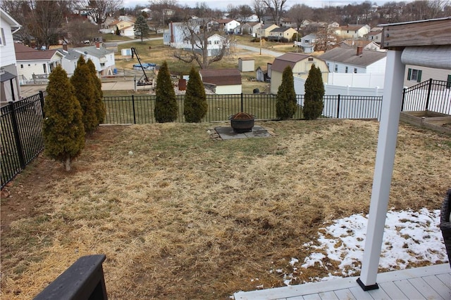 view of yard with a residential view, an outdoor fire pit, and a fenced backyard