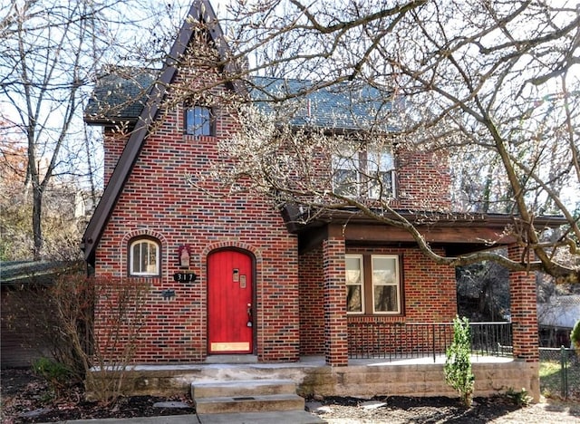 tudor home featuring brick siding