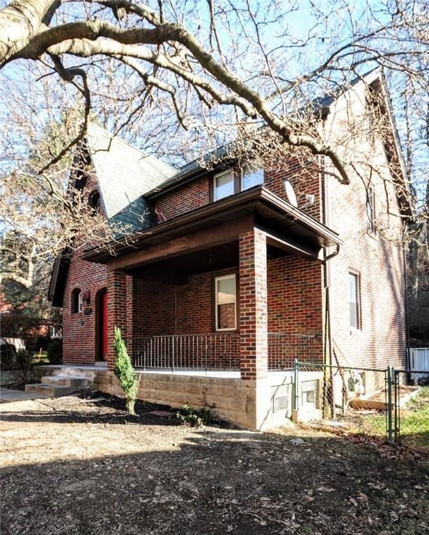 view of home's exterior with a porch and brick siding