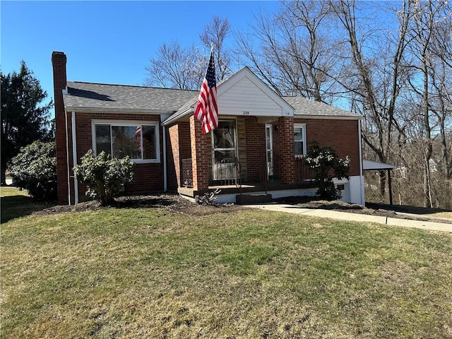 view of front facade with brick siding, a chimney, and a front yard