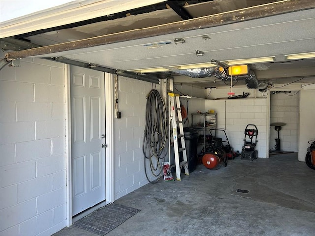 garage with concrete block wall and a garage door opener