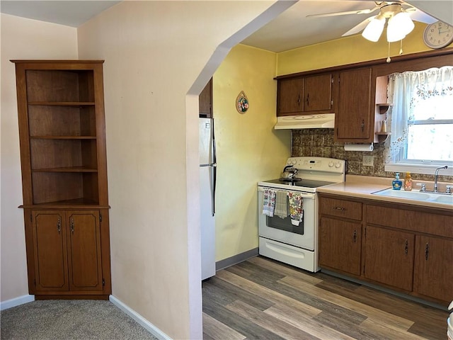 kitchen with open shelves, freestanding refrigerator, a sink, electric stove, and under cabinet range hood