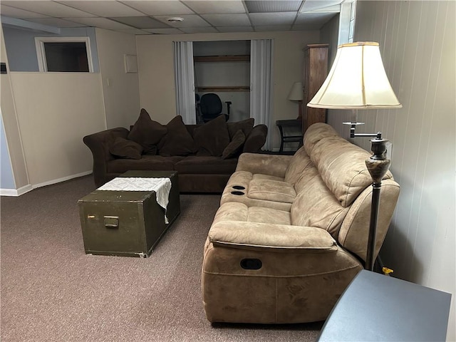 carpeted living area with a paneled ceiling and baseboards