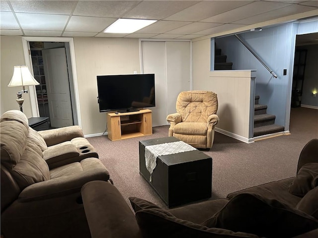 living room with stairway, baseboards, a paneled ceiling, and carpet