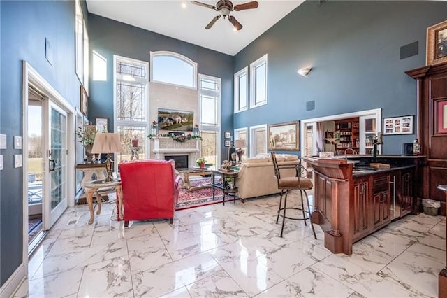 4605 Whippoorwill Dr, Hermitage, PA 16148 - living area featuring a towering ceiling, a ceiling fan, light marble finish floors, plenty of natural light, and a fireplace