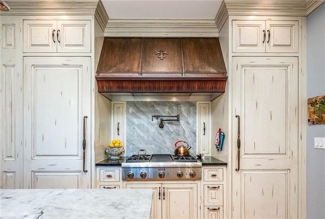 4605 Whippoorwill Dr, Hermitage, PA 16148 - kitchen with stainless steel gas cooktop, tasteful backsplash, cream cabinetry, custom exhaust hood, and crown molding