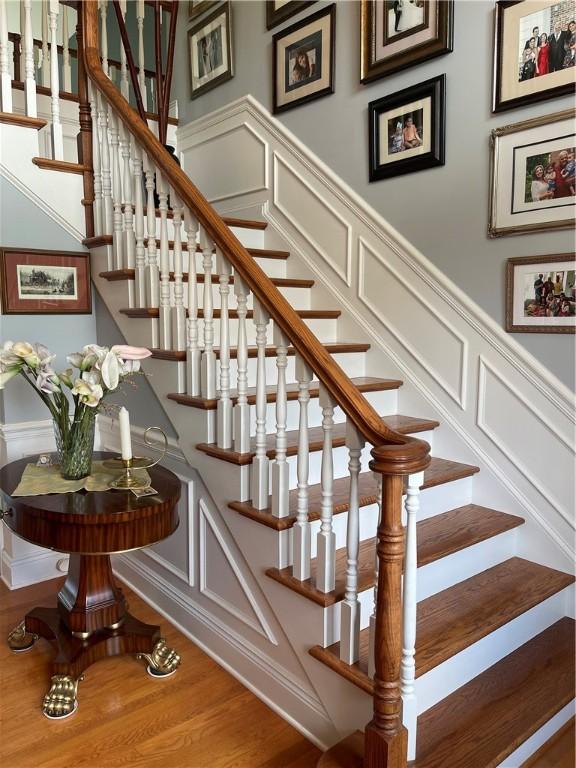 4605 Whippoorwill Dr, Hermitage, PA 16148 - stairs with a decorative wall, wood finished floors, and a wainscoted wall