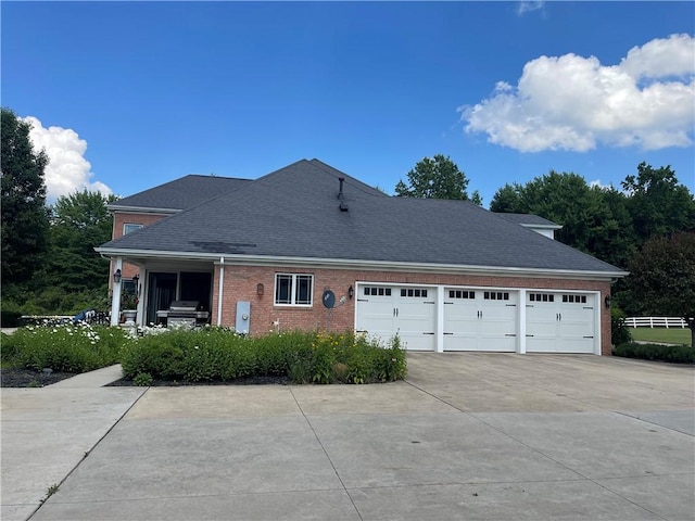 4605 Whippoorwill Dr, Hermitage, PA 16148 - view of side of property with driveway, a garage, brick siding, and a shingled roof
