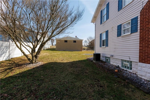 view of yard featuring fence and central AC