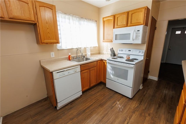 kitchen with white appliances, light countertops, dark wood-style flooring, and a sink