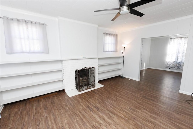 unfurnished living room with baseboards, wood finished floors, a brick fireplace, and ornamental molding