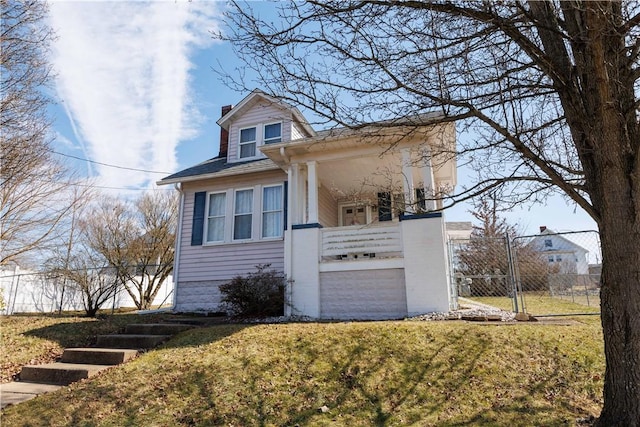 view of front of home featuring a gate, a chimney, a front yard, and fence