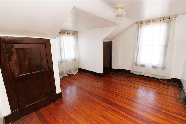 additional living space with baseboards, vaulted ceiling, and hardwood / wood-style flooring