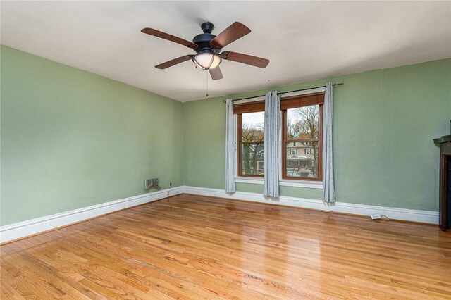 empty room featuring light wood-style flooring, baseboards, and ceiling fan