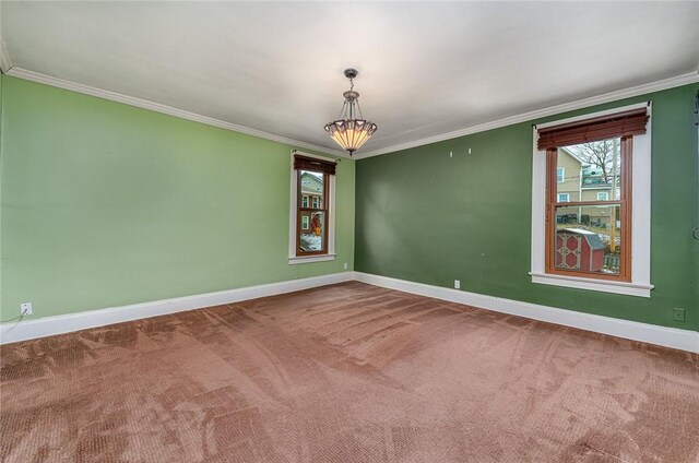 carpeted spare room featuring crown molding and baseboards